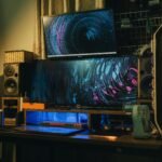 A cozy indoor modern computer setup with dual monitors and creative lighting.