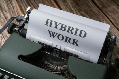 Trabalho Híbrido em 2026, O Novo Normal das Empresas Retro typewriter with 'Hybrid Work' text, symbolizing modern work trends.